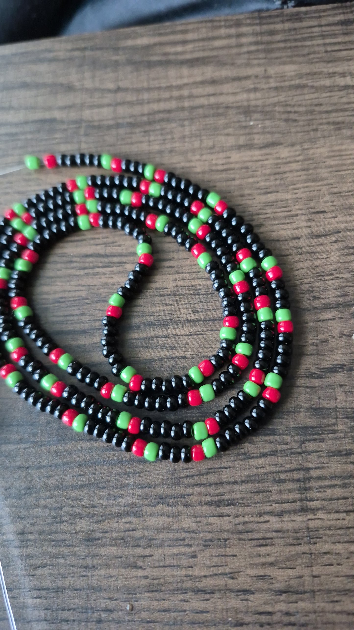 Pan African flag themed black, red and green tie on waistbead